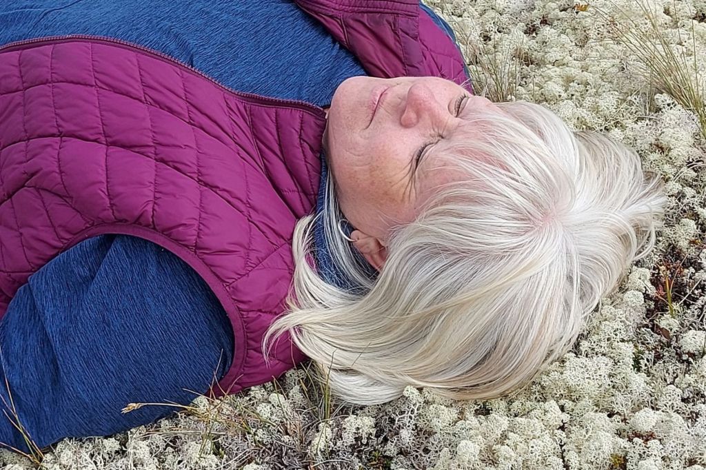 Marie allongée sur un lit de fleur médite les yeux fermés